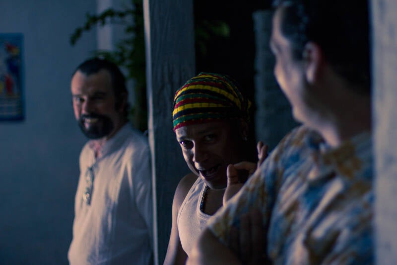 Night exterior scene with three actors staged at different depths