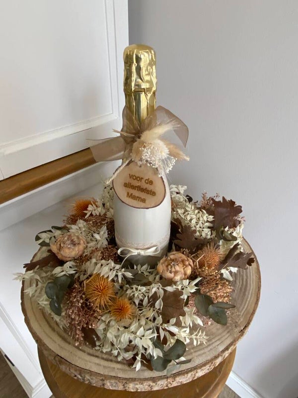 Bloemen krans met cava fles op boomschijf