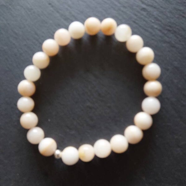 Licht abrikooskleurig agaat armband met een zilveren  kraal