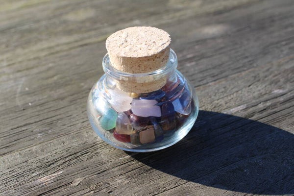 Glazen flesje met gemengde stenen