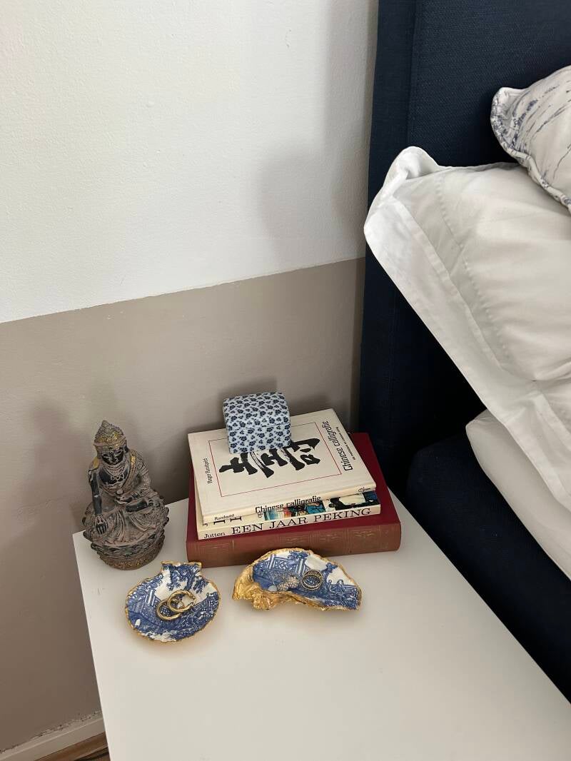 gouden oesterschelp naast het bed