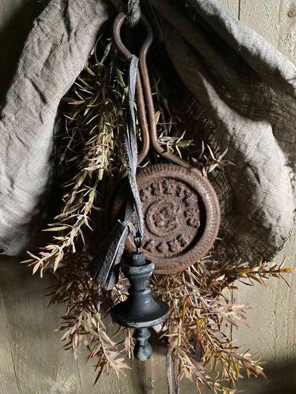 Metalen ornament met leren kwastje en houten klosje