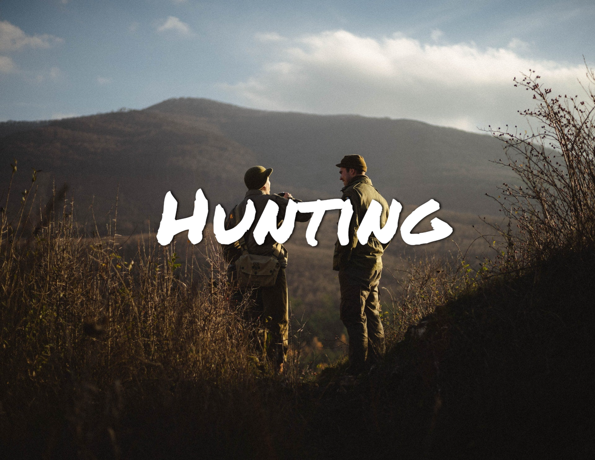 Two men in camo hunting in the hills
