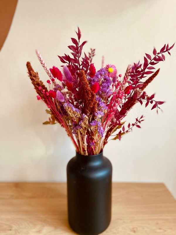 Zwarte vaas met droogboeket fuchsia en paars
