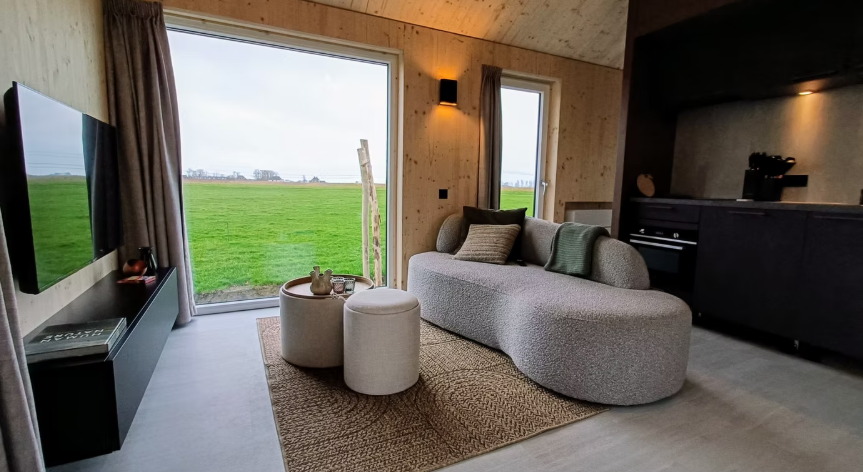 Compacte woonkamer met zithoek en keuken.