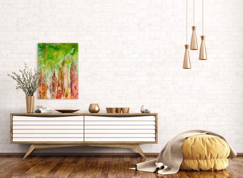 Boven het wandmeubel aan de witte muur hangt een figaratief schilderij waarop de schors van bomen en gebladerte te zien is.