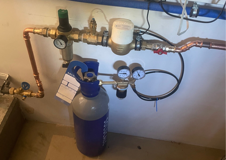 Close-up van een geplaatste SoluCalc CO₂-waterontharder met filter, drukregelaar en leidingen – duurzame oplossing tegen kalkaanslag.