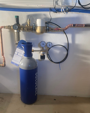 SoluCalc waterontharder professioneel geïnstalleerd met drukregelaar, manometers en koperleidingen – voorbeeld van een correcte plaatsing bij de watermeter.