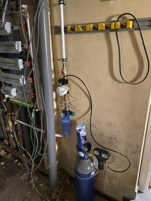 Installatie van SoluCalc waterontharder met koperleidingen, drukregelaar en CO₂-fles in kelder
