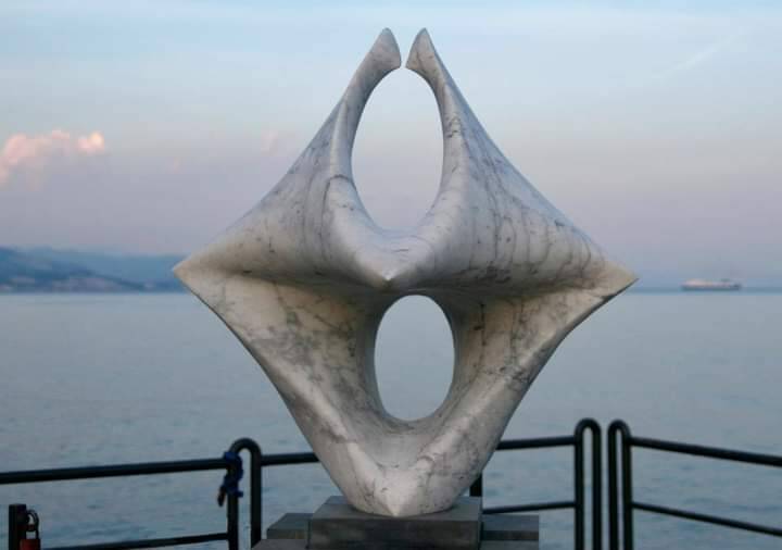 Daytime close-up view of the original marble 'Windrose' sculpture (Windrose, Prototype), installed on the coastline, showing the full intricate geometric structure before its destruction.