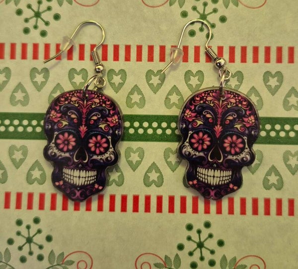 Leuke zwarte Skulls oorbellen met roze bloemen.