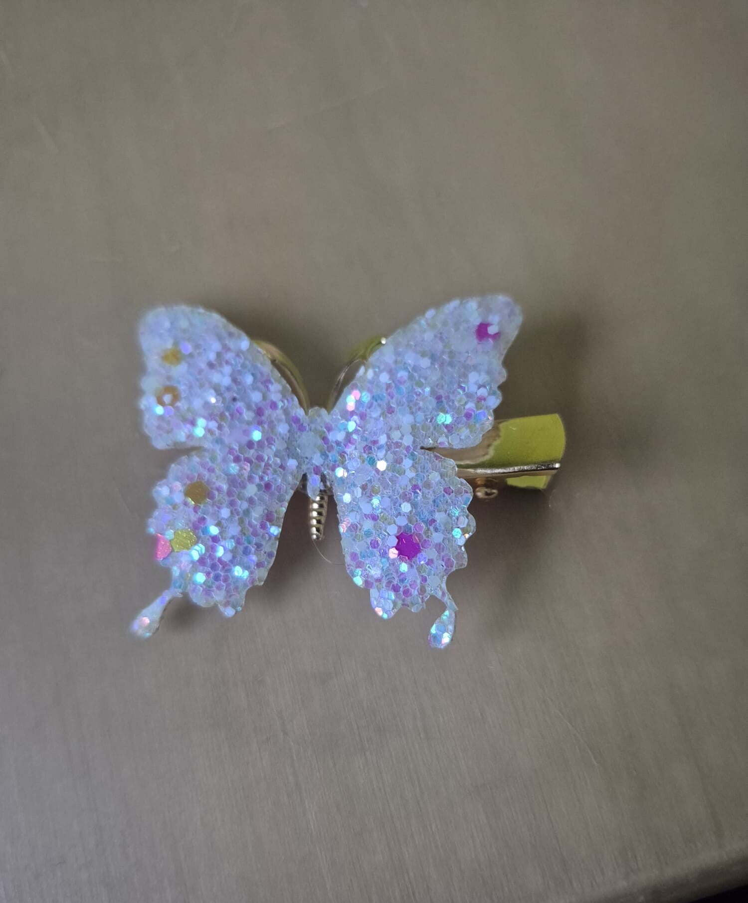 Mooie klem of broche van een witte vlinder met pailletjes. Glow in the dark.