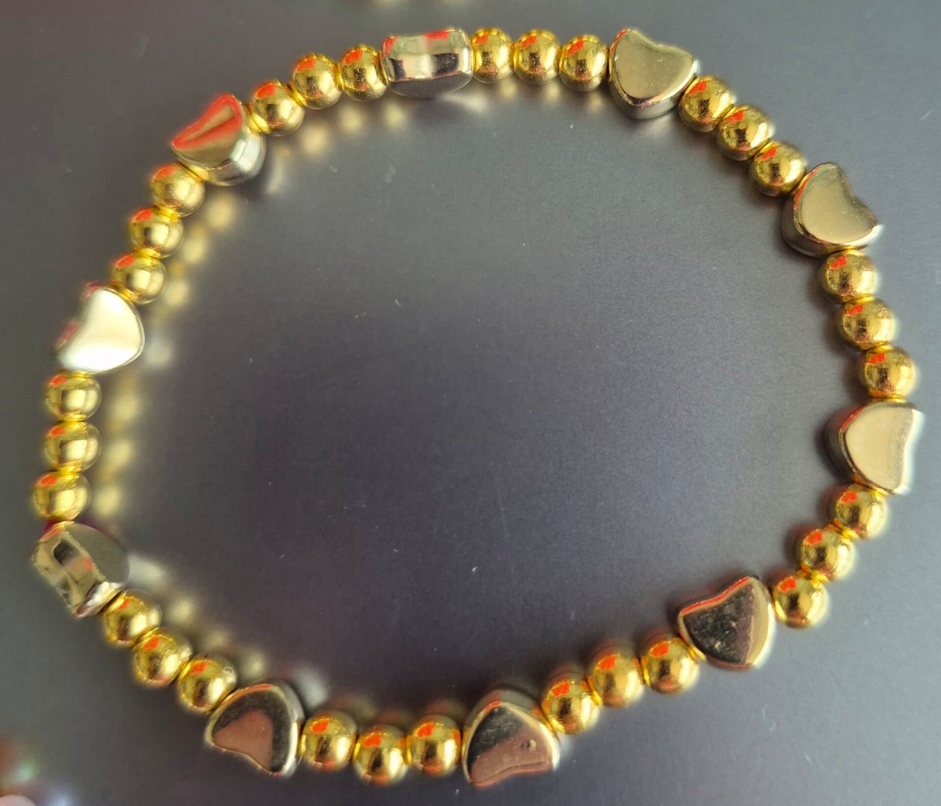 Schattige armband met gouden kraaltjes en hartjes ertussen. Voor kinderen.