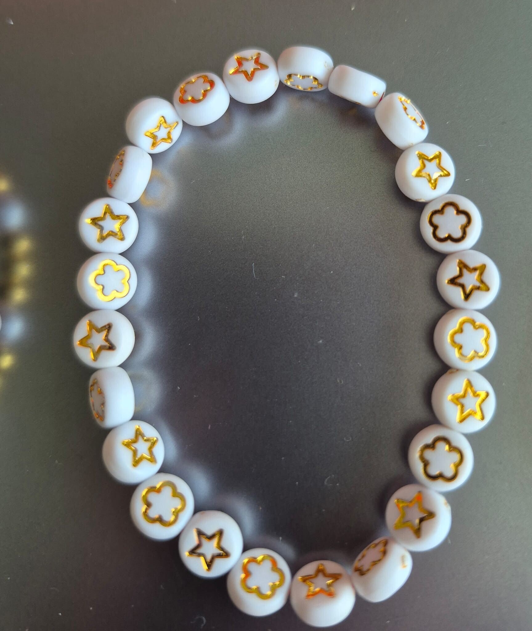 Mooie kinderarmband met sterretjes en bloemetjes.