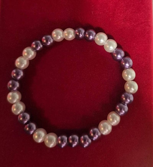 Mooie armband met paarse en witte kralen.