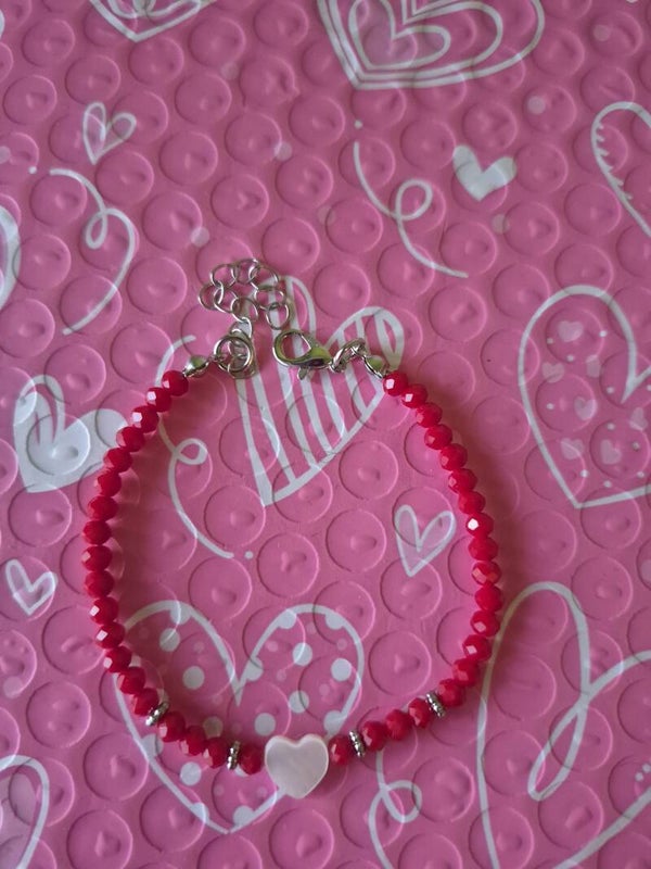 Mooie rode armband met een leuk wit hartje en een verlengketting. Voor dames.