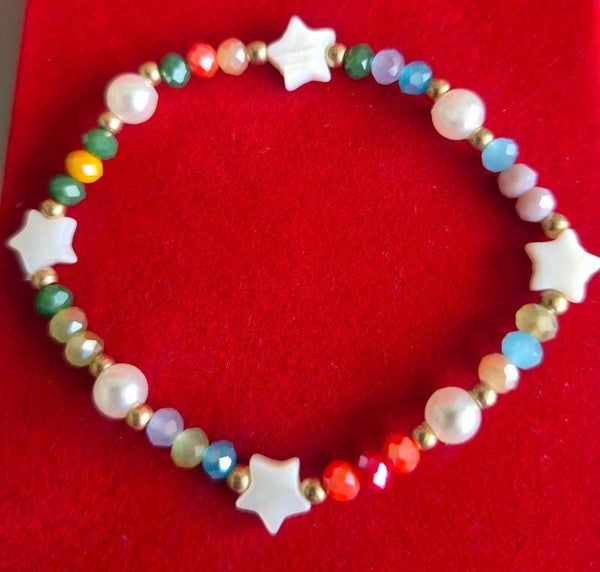 Gave armband met kleurrijke kraaltjes en witte sterretjes.