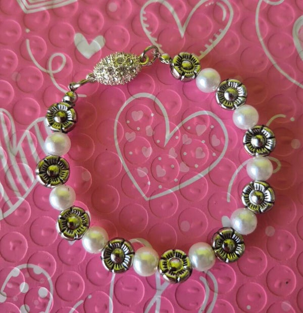 Prachtige armband met parels en bloemen. Met een magneetsluiting.