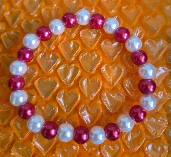 Leuke armband met rode en witte kralen.