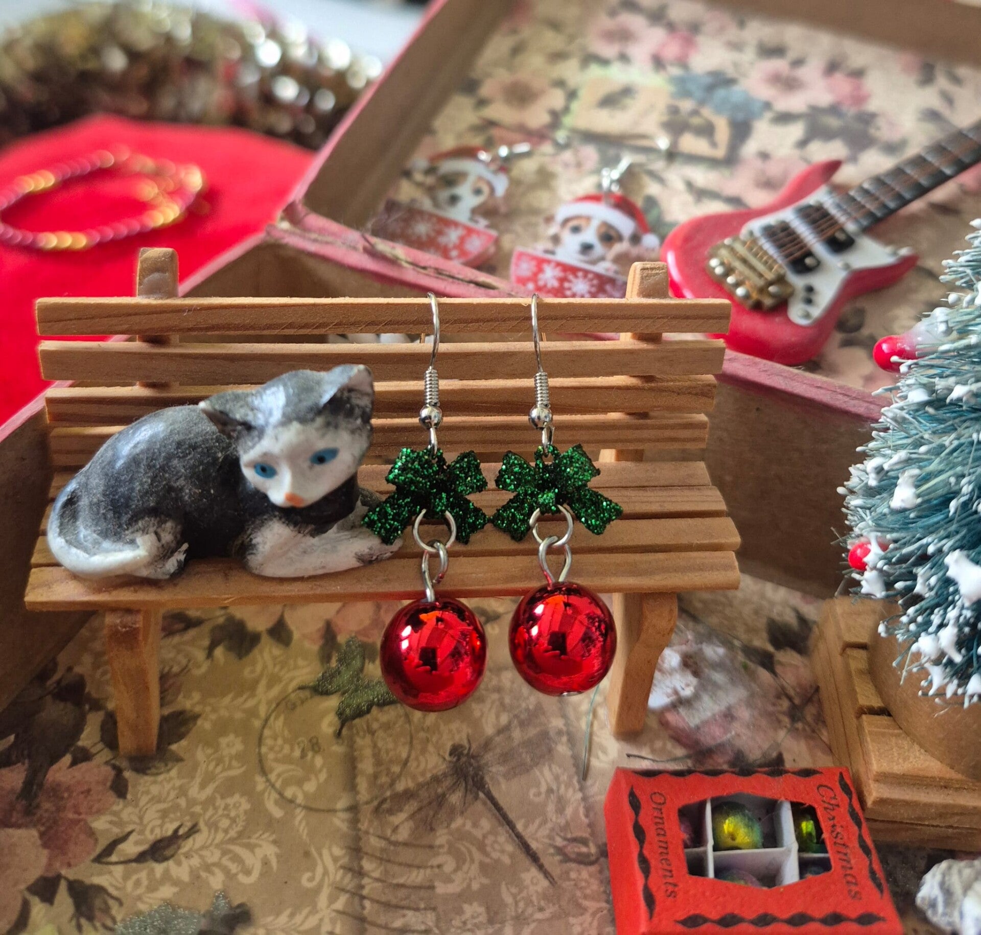 Mooie rode kerstbal oorbellen met groen strikje.