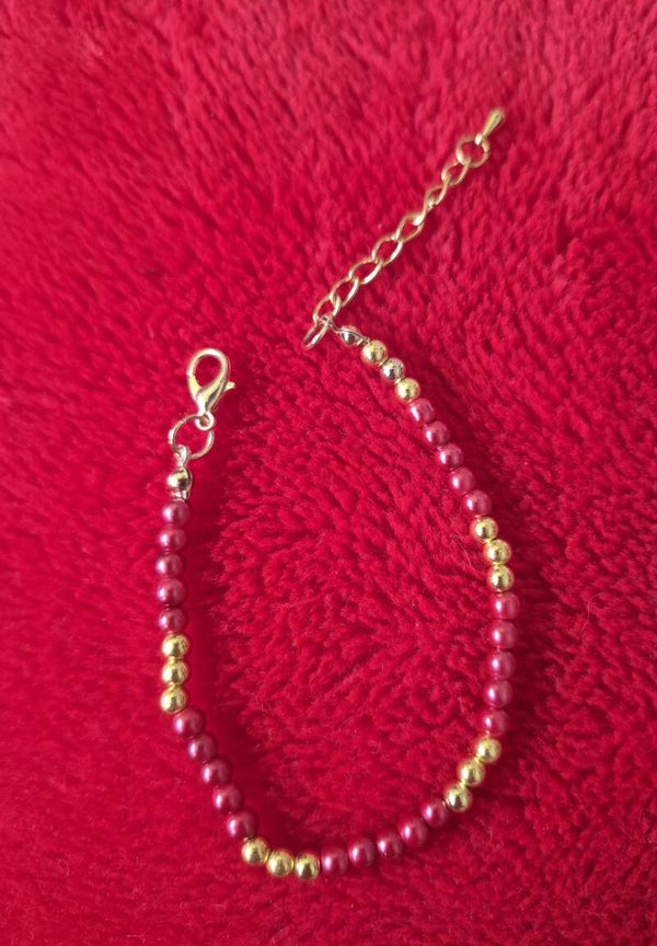 Gave armband, in de kleuren goud en rood.