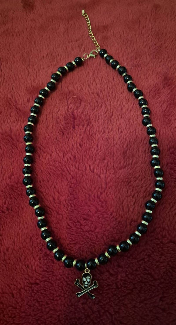 Halloweenketting met zwart, en gouden kralen. Mooi afgewerkt met een karabijnsluiting, een bedeltje en een verlengkettinkje.