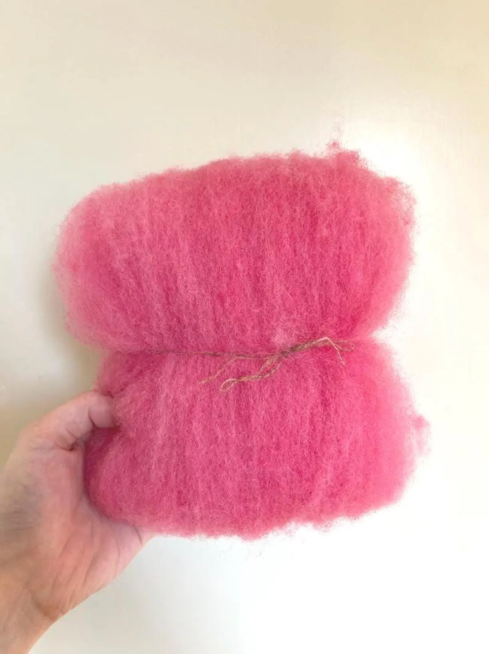 Handgeverfde wollen tussenvulling: ethisch naaldvilten, spinnen en breien