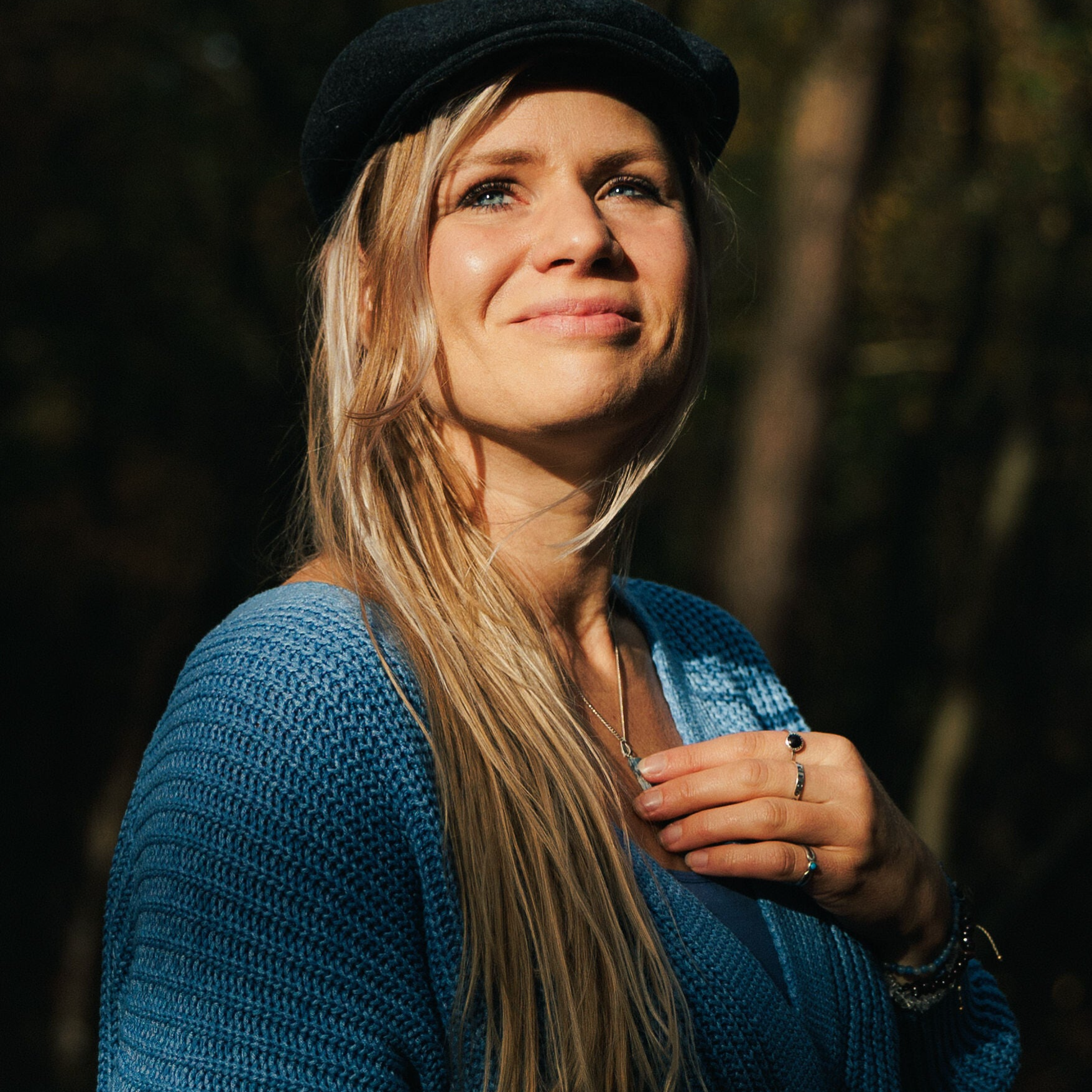 Illustrator kijkt je aan vanuit een plek in de natuur.