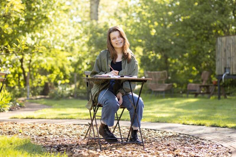 Illustrator Evie Mariek Meij aan het werk in de tuin van haar ouderlijk huis, illustratie in opdracht.