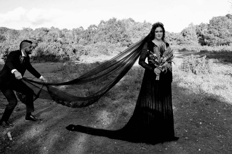 anything for the shot the groom fluffs the brides black veil