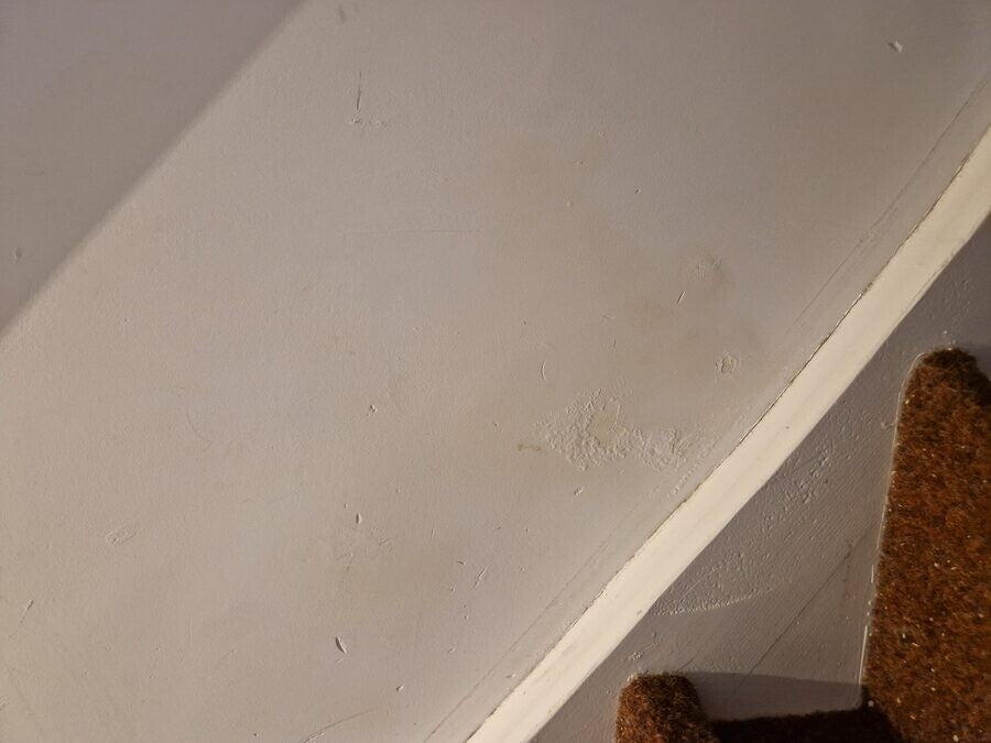 Vochtplek en waterschade op muur bij trapgat door lekkage - lekdetectie Amsterdam