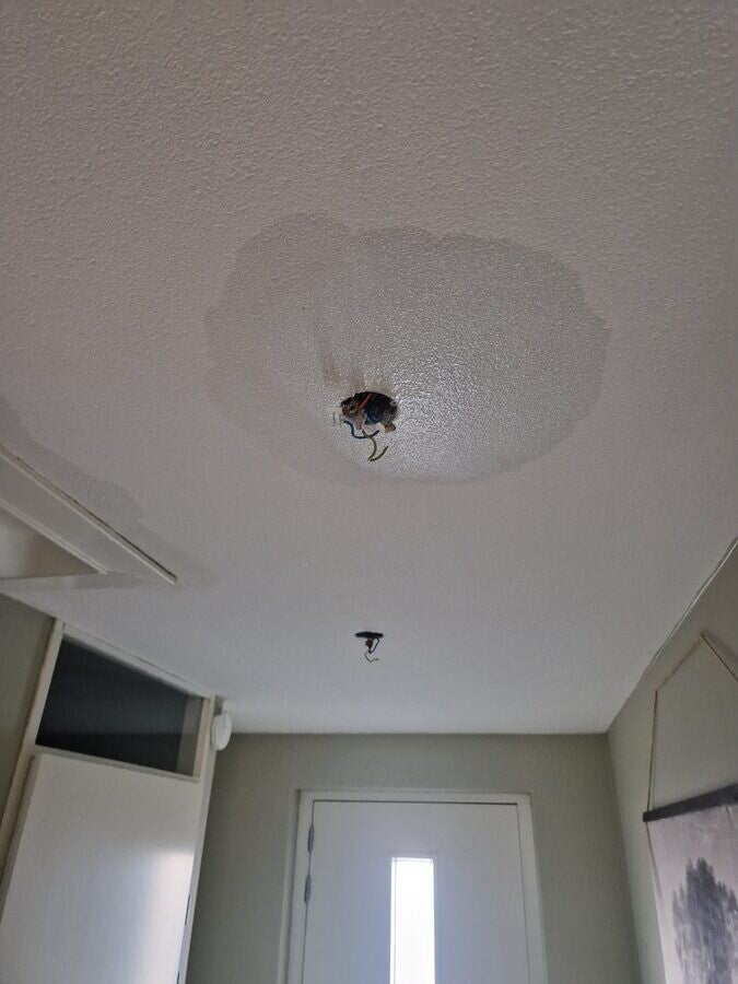 Waterschade in plafond met beschadigde bedrading door waterlekkage - Amsterdam