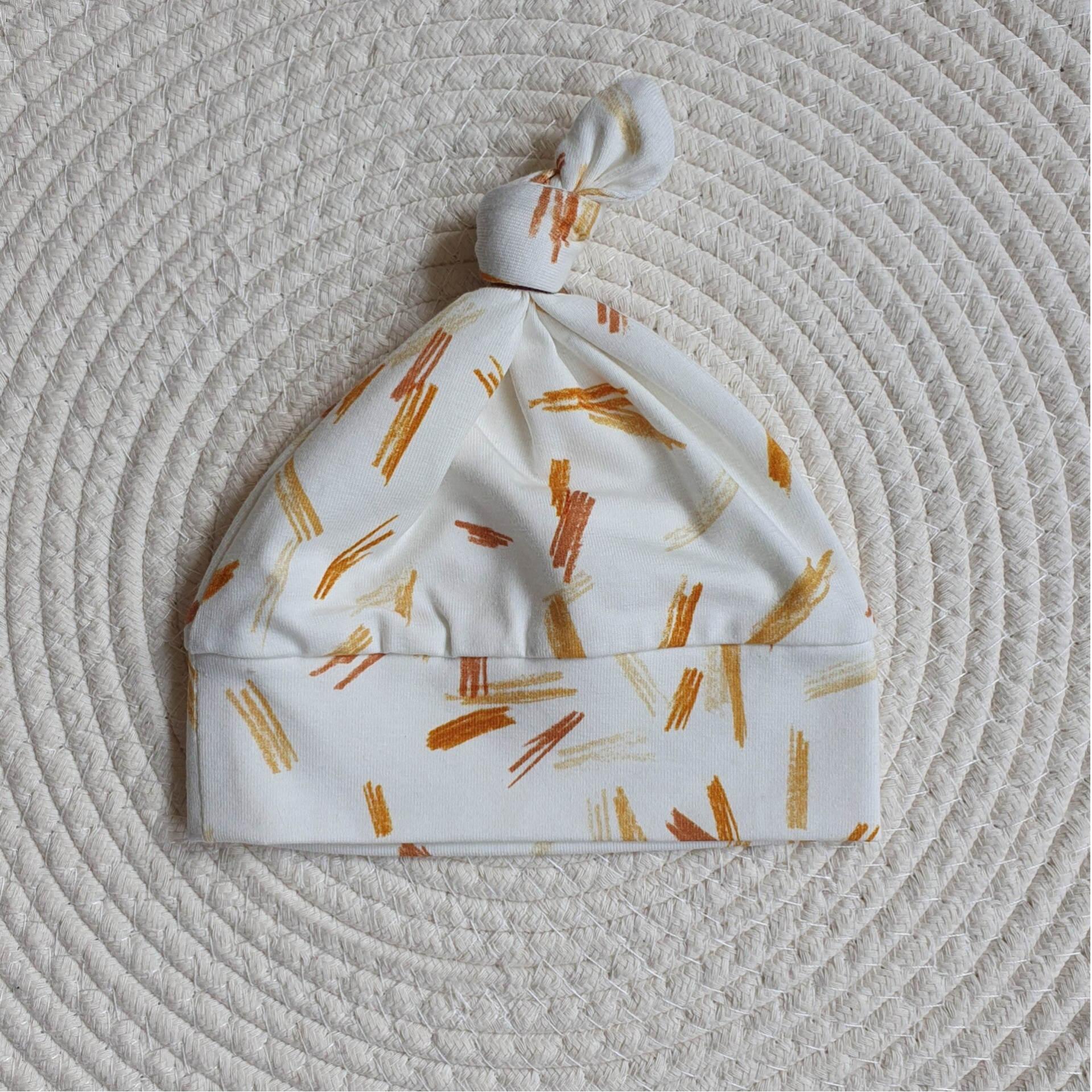 Knoopmutsje met veeg strepen.