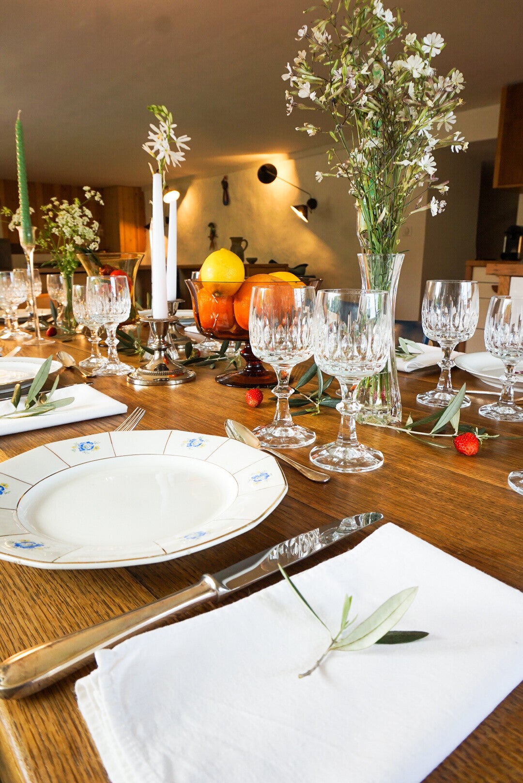 Table dressée de manière élégante avec vaisselle vintage et fleurs séchées dans des vases en cristal