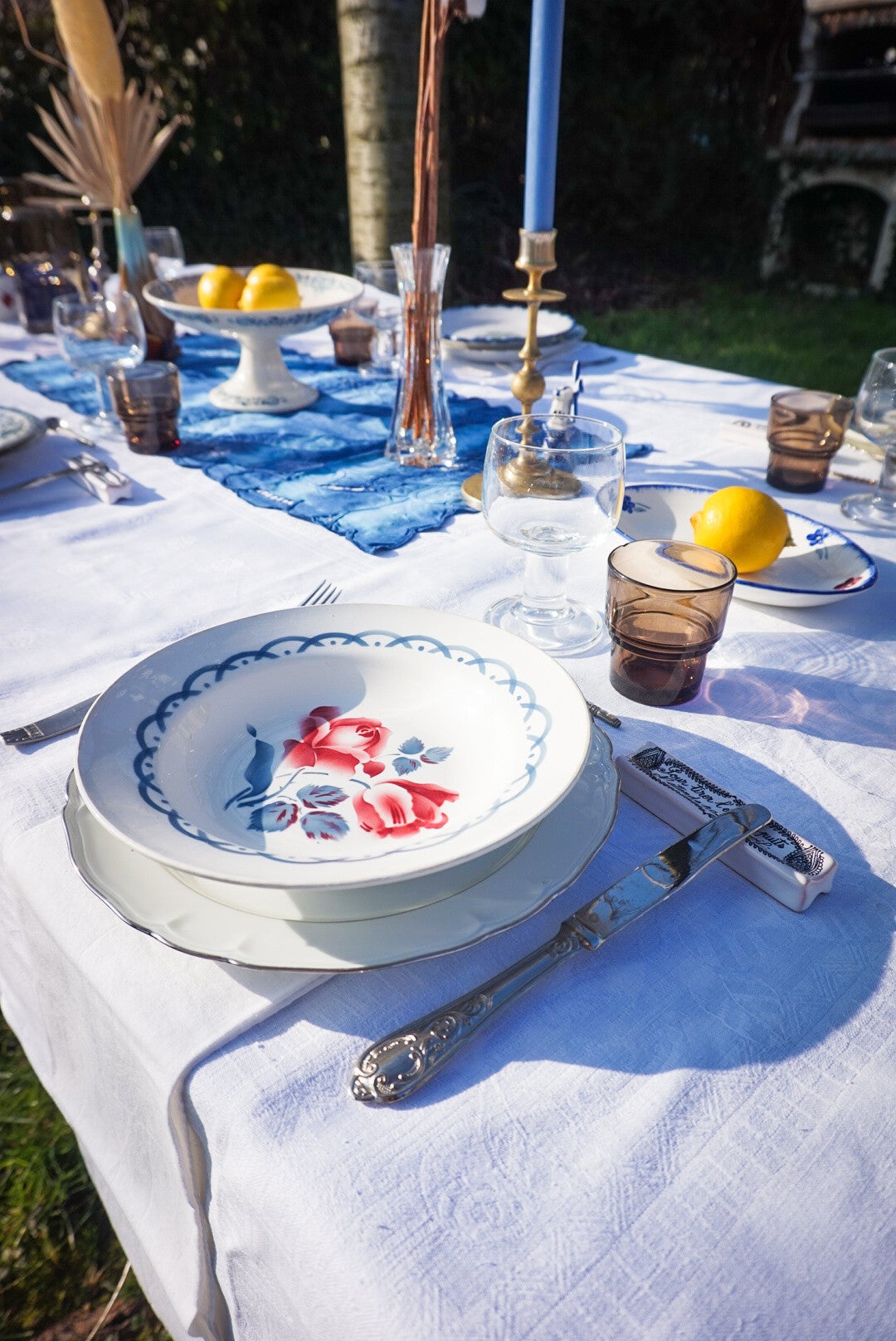 Vaisselle de style sixties disposée sur une nappe ancienne en coton blanc