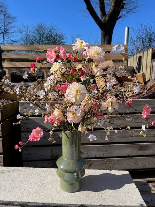 Bloesemboeket met rozen op olijfgroene vaas