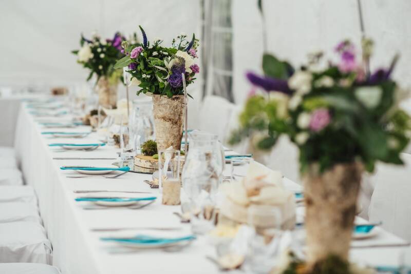 A wedding reception table with place settings and flowers