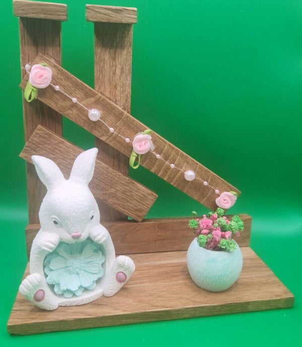 Osterhase auf einer Holzterrasse mit Blumen