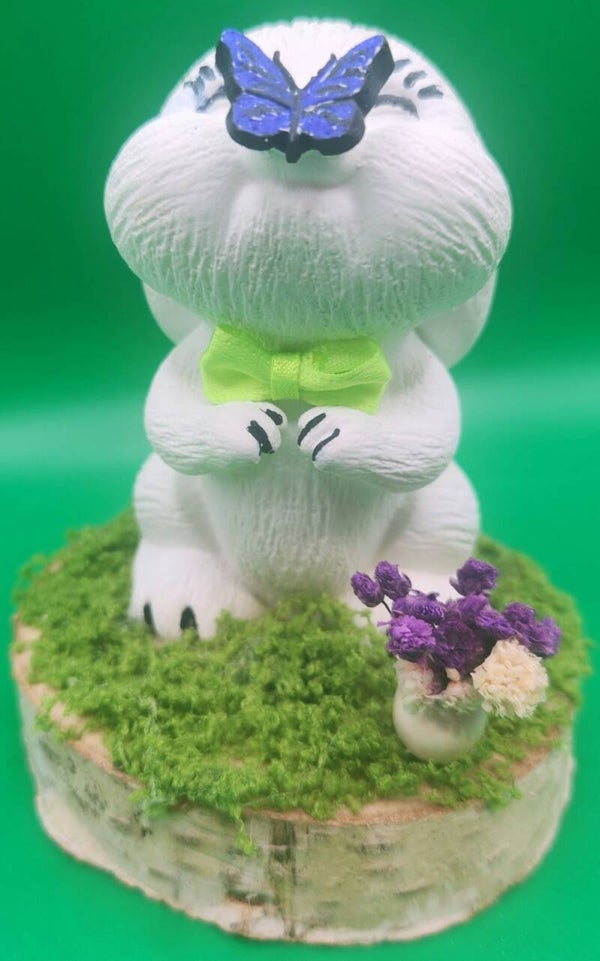 Osterhase auf Holz scheibe mit Rasen und Blume