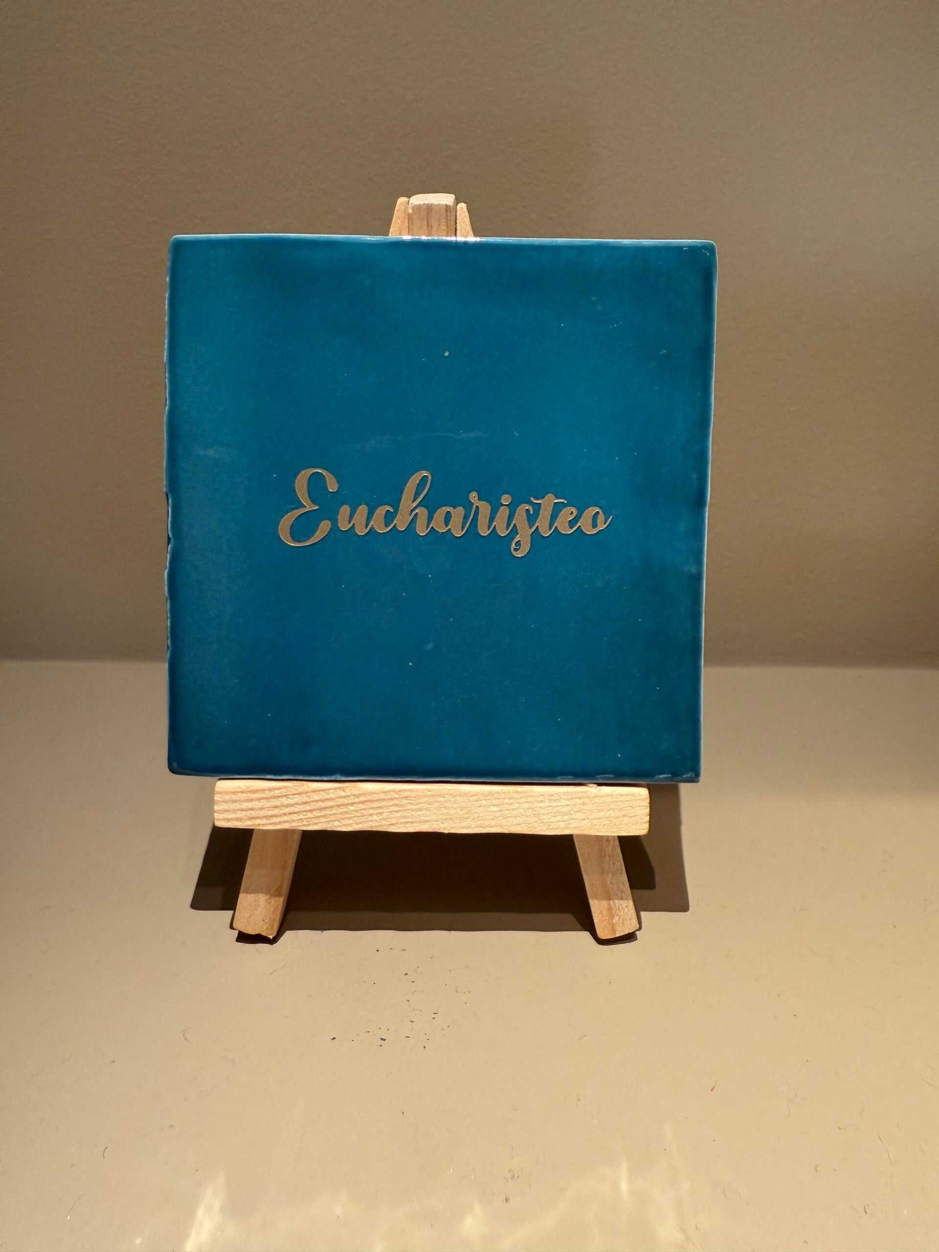 Tegel met tekst 'Eucharisteo' - petrolblauw