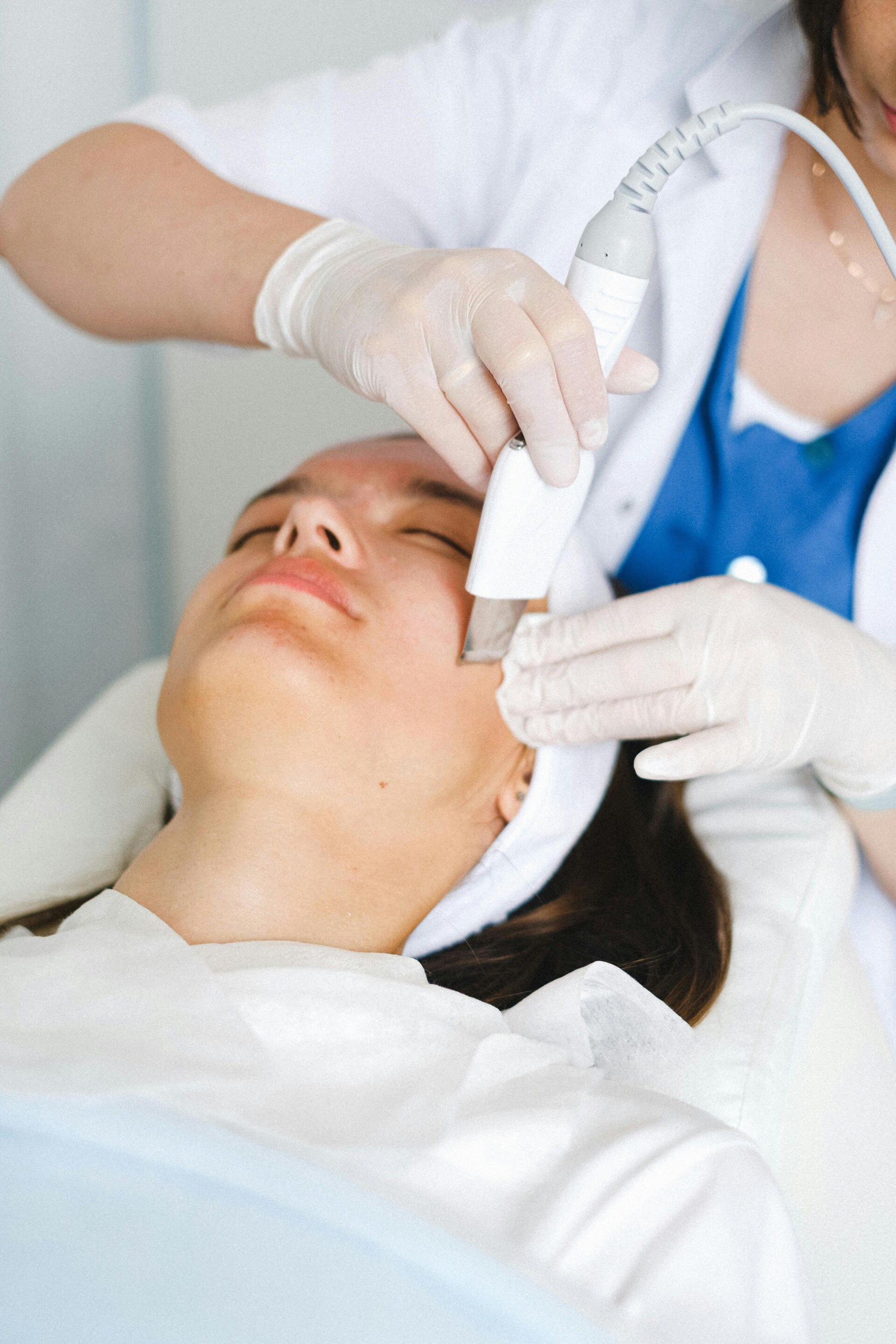Cosmetóloga haciendo una limpieza facial con un skin scrubber a una mujer para tratar el acné