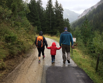 A family with small child hiking on a trail, symbolizing peace of mind and protection.