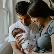 Mom, dad, and newborn baby symbolizing children’s life insurance and the lasting value it provides for their future