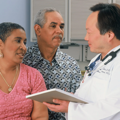 Husband and wife speaking to doctor, symbolizing how a cancer policy provides an extra layer of protection to help cover unexpected expenses after a diagnosis