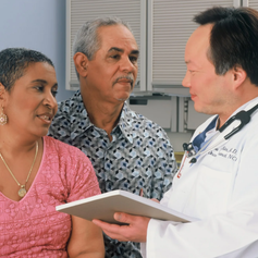 Husband and wife speaking to doctor, symbolizing how a cancer policy provides an extra layer of protection to help cover unexpected expenses after a diagnosis