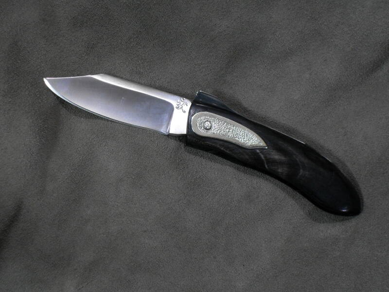  COLTELLO A TRE SCROCCHI E MOLLA FISSA  LAMA IN ACCIAIO INOX 12C27 TEMPRATA A 55 HRc  IMPUGNATURA IN CORNO DI BUFALO  PIASTRA ORNAMENTALE IN ALPACCA.