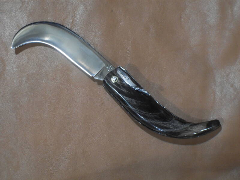 RONCOLA A UNO SCROCCO, MOLLA FISSA E LEVA DI CHIUSURA LATERALE  LAMA IN ACCIAIO INOX N690 TEMPRATA A 58 HRc  IMPUGNATURA IN CORNO DI BUFALO