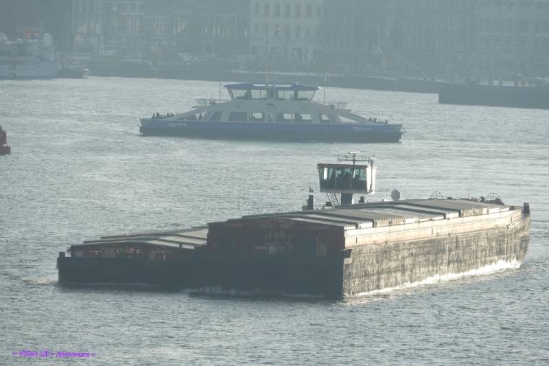 in morning mist pusher METAMORFOSE with barges and behind it IJVEER 63
