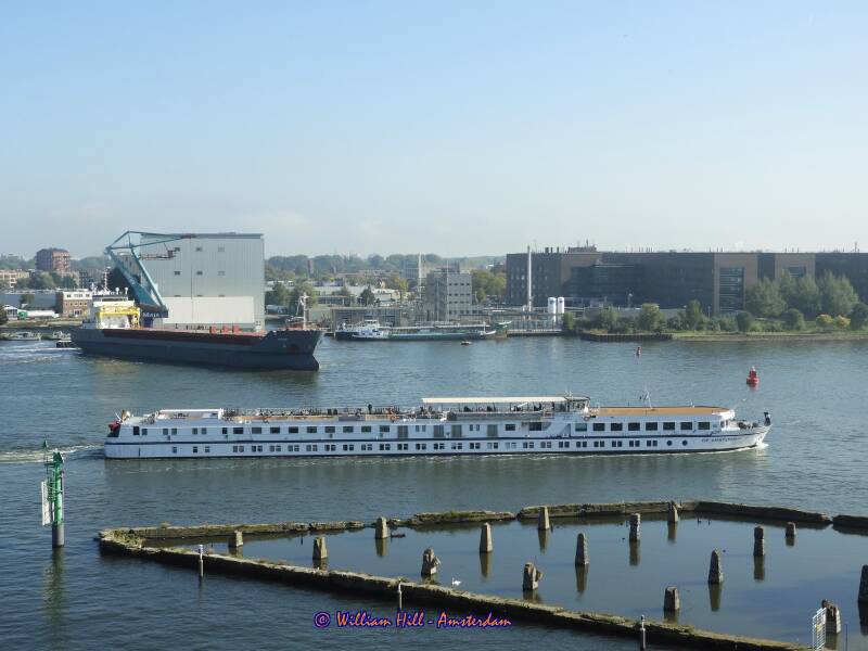 German rivercruise DE AMSTERDAM passing the old pier &#039;Het Stenenhoofd&#039;and a departing KVITSAND started the turn