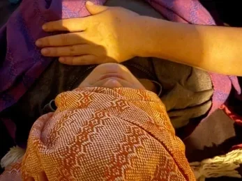 Persona in una posizione di apertura e ascolto profondo, dedicata alle pratiche di respiro e consapevolezza.